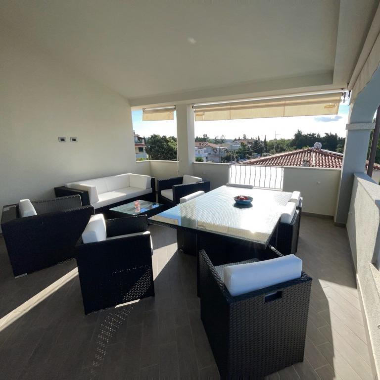 Überdachter Balkon mit Sitzgruppe und Glastisch in Orosei